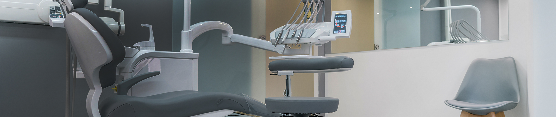 The image shows a modern dental clinic interior with various pieces of equipment, including a dental chair and an X-ray machine.