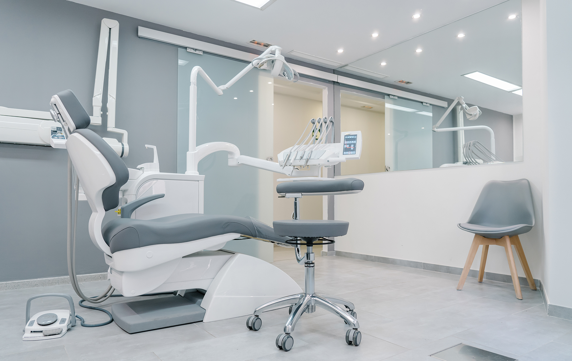 A modern dental office with a large chair and equipment on display.